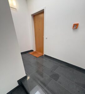 Sauberes Treppenhaus, Schwarzer Flur und Wohnungstür